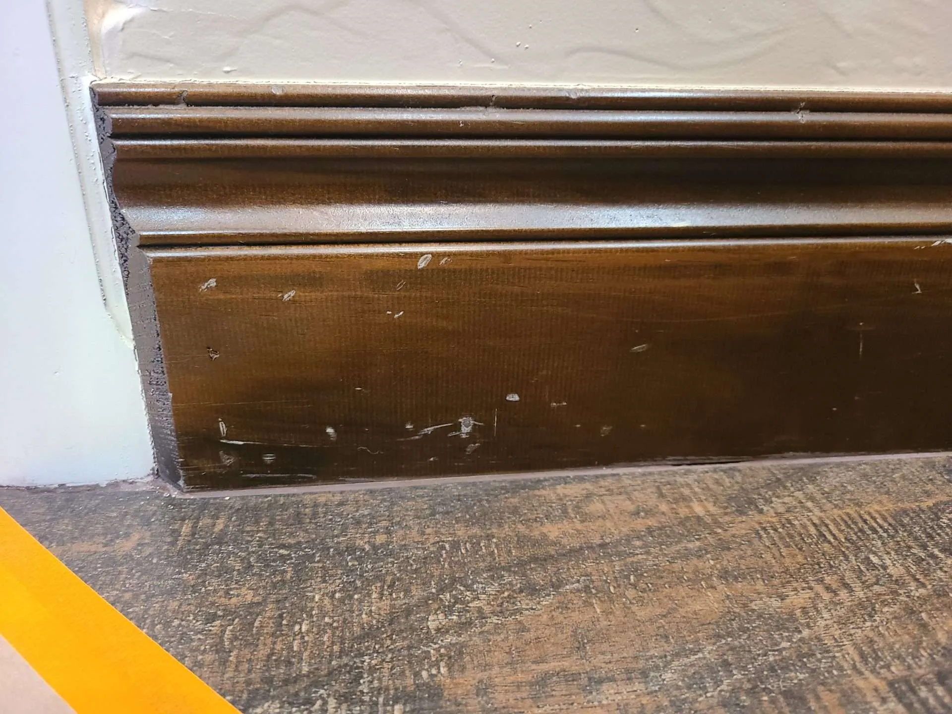 20241223_093833 Baseboard with visible nicks and scratches before stain touch-up