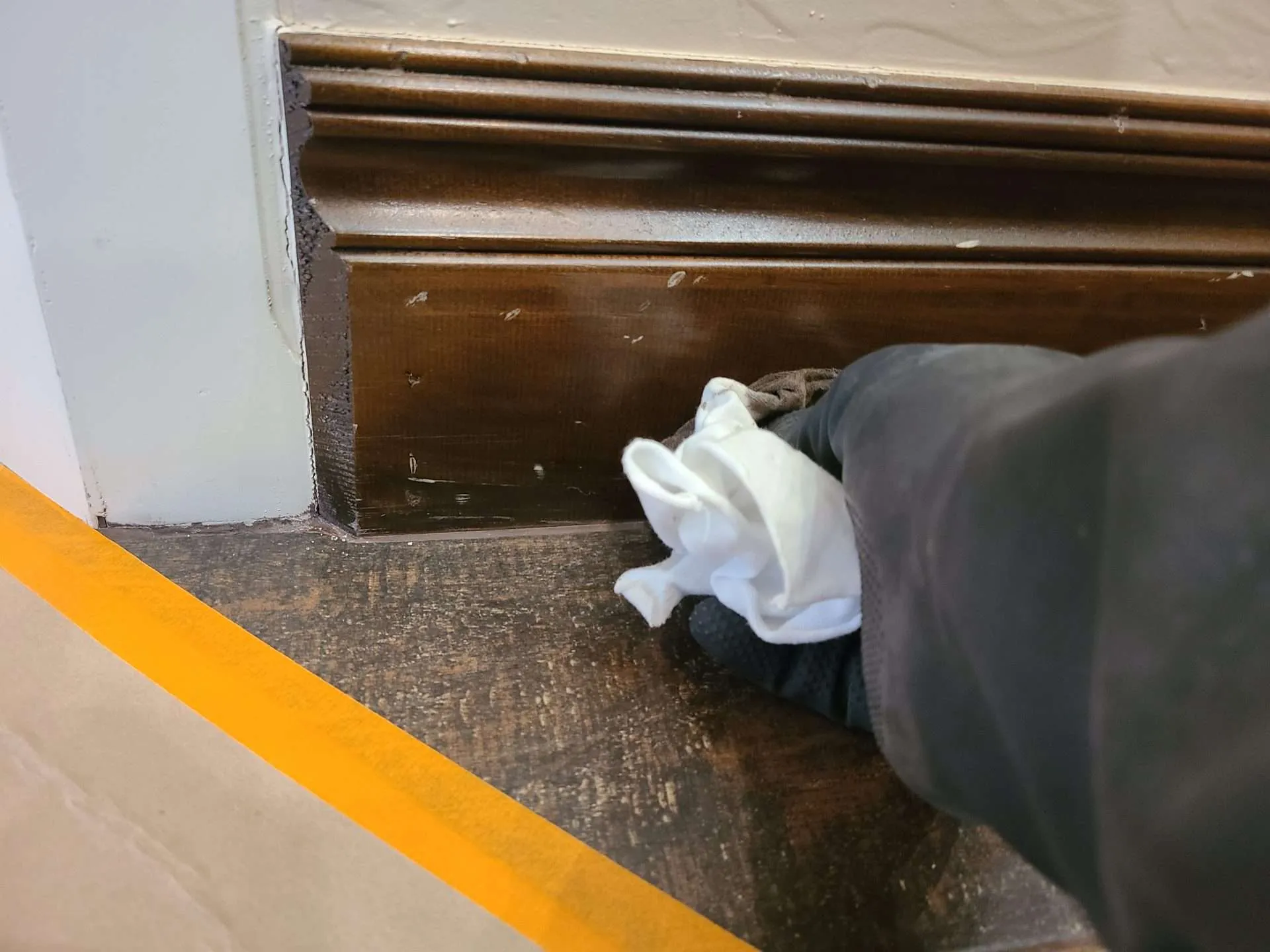 20241223_093838 Applying stain with a cloth to fix scratches in stained wood trim