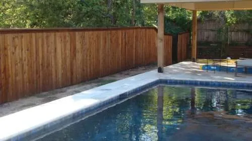 DSC05397 after shot of a pool around a fence that has just had wood defender stain applied to it.