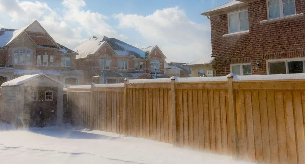 Fence in Snow a picture of a wood fence in the snow showing what isn't the best time to stain a fence