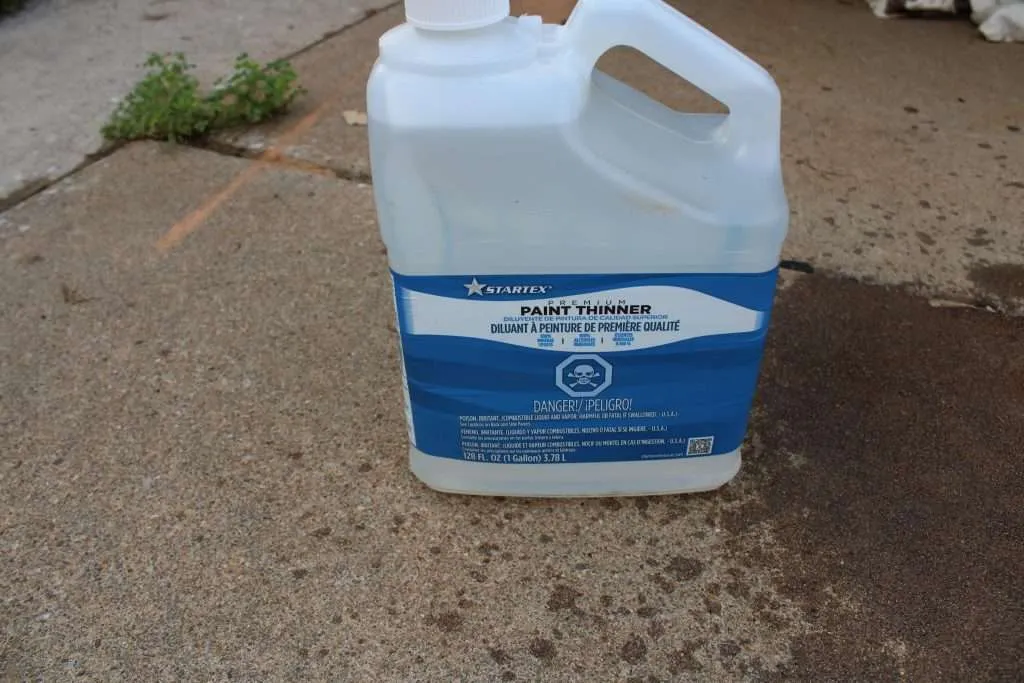 IMG_1621 a can of paint thinner next to a spill of oil-based stain.