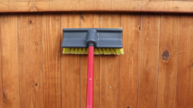 brush cleaning fence a brush cleaning a fence with an up and down motion following the boards