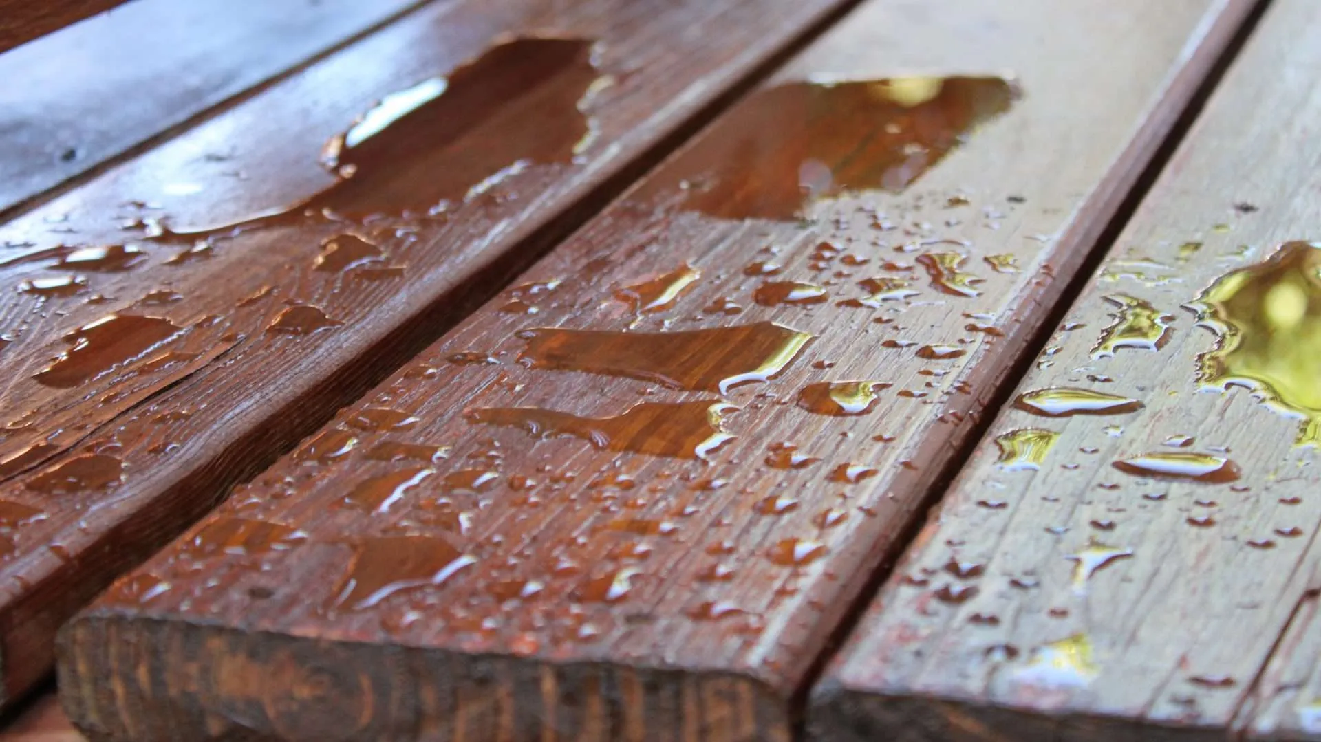 Moisture Protection a picture of stained cedar boards with water beading up on them.