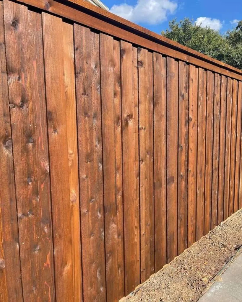 Oxford Brown Wood Defender a tall cedar fence with wood defender oxford brown stain applied to it.