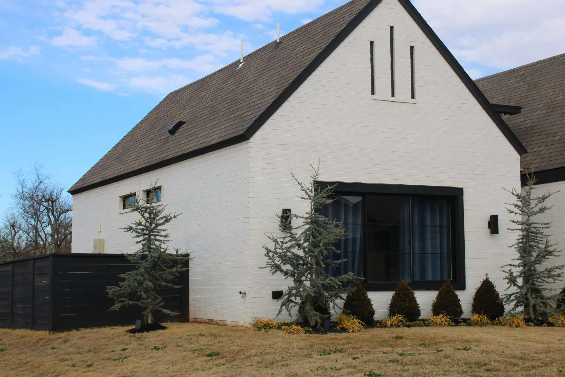 black stain fence a white painted house with a black fence